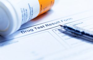 drug test result form with bottle and pen