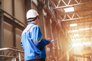 inspector with clipboard wearing hard hat