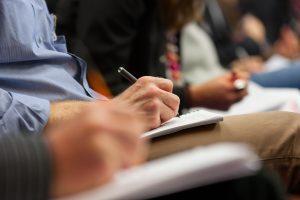 Close-up of Hands holding pens and making notes at the conference